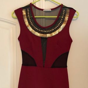 Maroon dress with cutouts and gold detail.